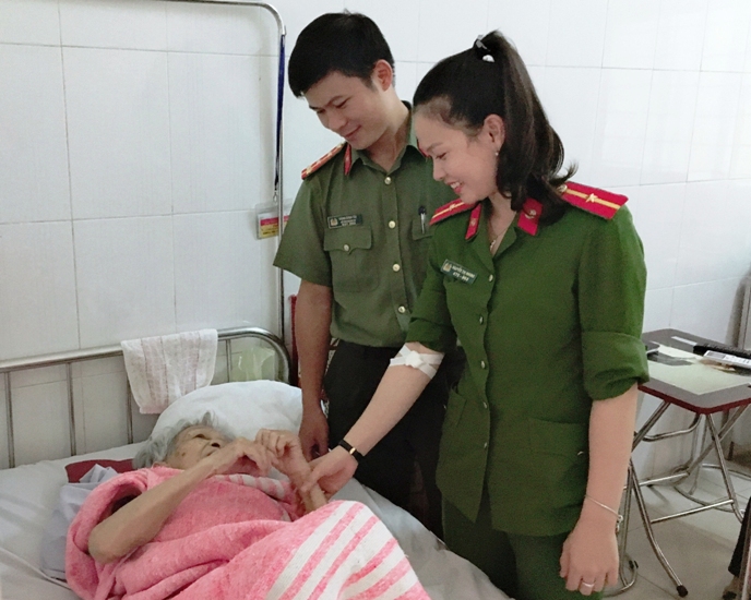 Thiếu úy Nguyễn Thị Nhungthăm hỏi bệnh nhân Trần Thị Yêm sau khi hiến máu.
